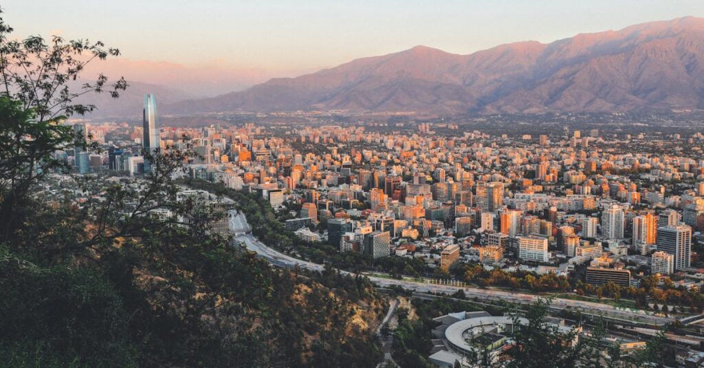 Breathtaking view of Santiago, Chile's skyline framed by mountains at sunset.