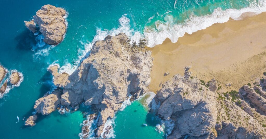 A breathtaking aerial view of Cabo San Lucas' iconic beach showcasing rocky shores and turquoise waters.